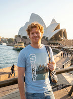 Person wearing a 'Sydney' t-shirt in front of the Sydney Opera House.