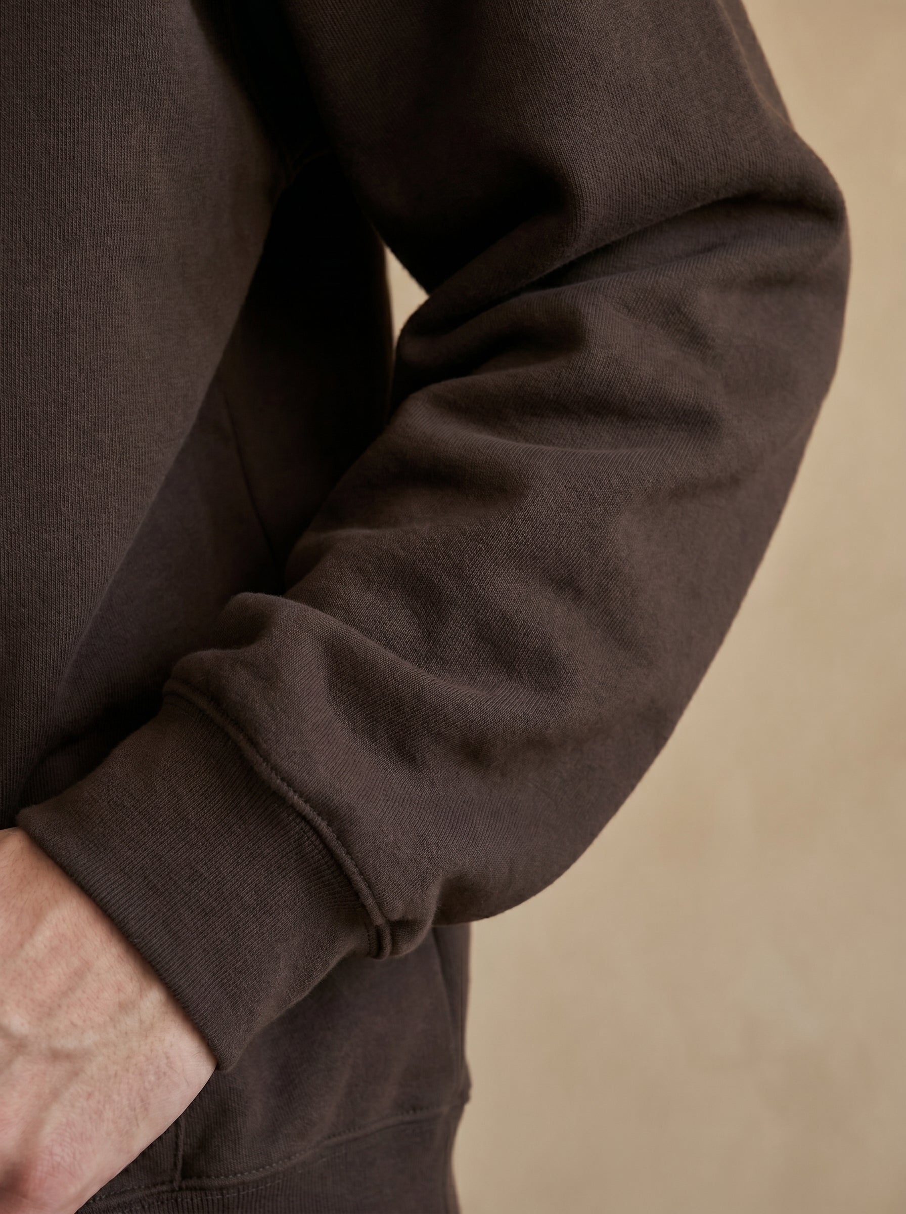 Close-up of a brown jacket sleeve on a beige background