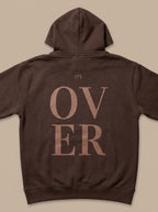 Brown hoodie with 'ITS OVER' text on the back against a beige background