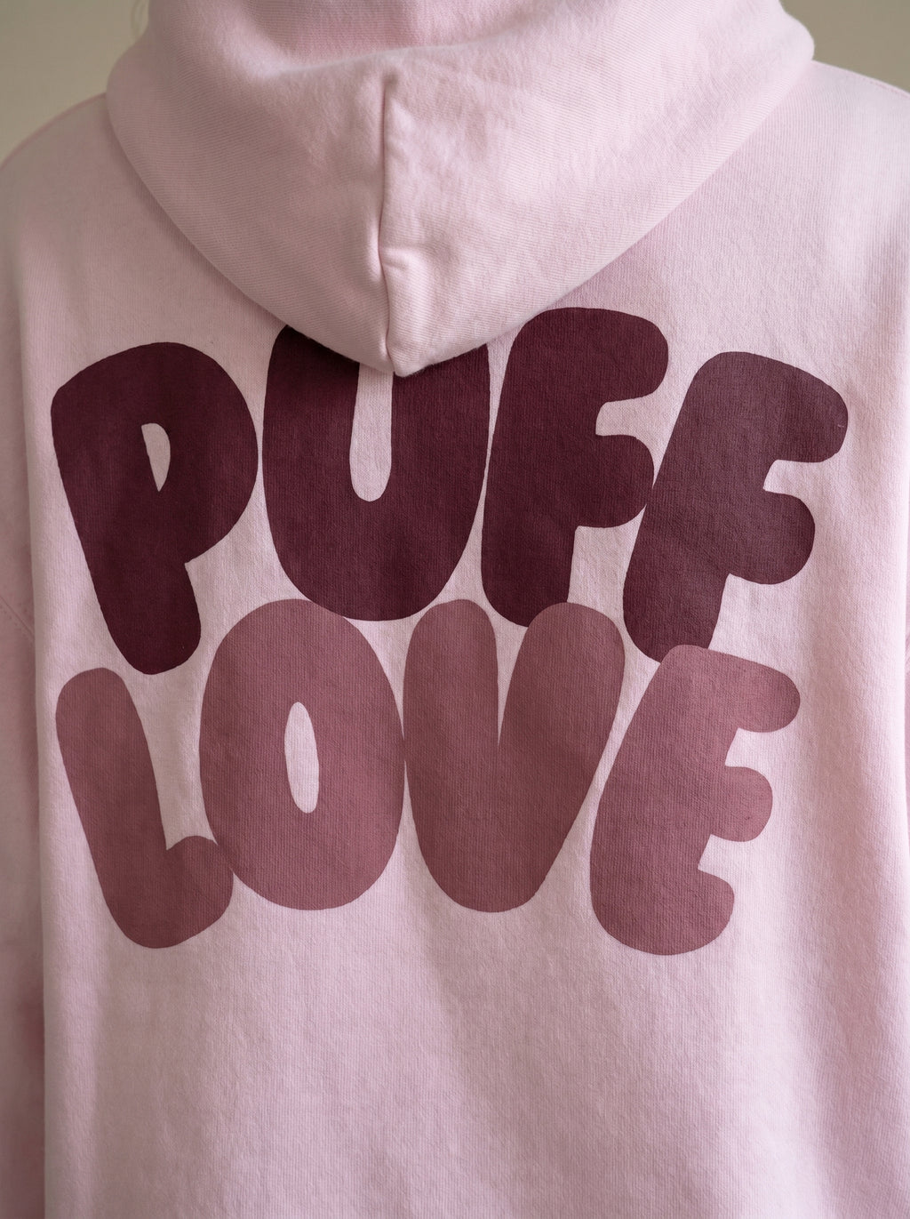 White hoodie with 'PUFF LOVE' text in maroon on a plain background